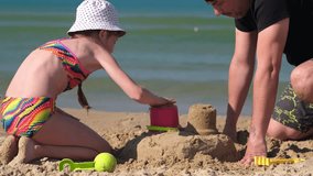 Father and child girl building sand castle at the beach. Kid with dad outdoors at seaside playing together  - Powered by Shutterstock - Get 15% off with code: PIKWIZARD15