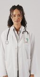 Vertical video of happy biracial female doctor looking at camera. health, medicine and doctor profession concept.
