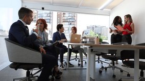 Business professionals in a lively discussion with a digital tablet in a modern workspace. Strategic Discussion with Digital Tools - Powered by Shutterstock - Get 15% off with code: PIKWIZARD15