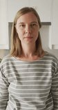 Vertical video of portrait of happy caucasian woman at home. spending time alone at home.