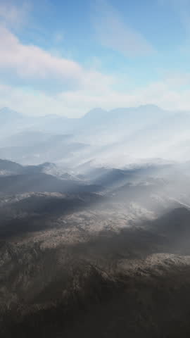 An aerial view of a mountain range with sunbeams