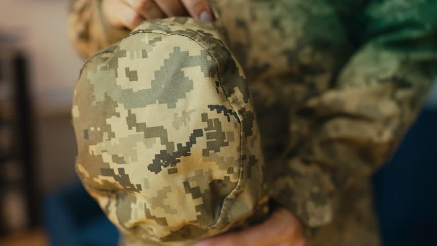 Beautiful female soldier putting on army hat, getting ready to leave for work
