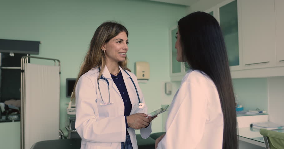 Two smiling Latin women general practitioners in white coats, shaking hands. Handshake between two therapists as symbol of productive, successful cooperation, support in therapeutic practice, teamwork Royalty-Free Stock Footage #3470259459