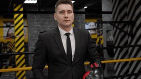 A happy, confident businessman in boxing gloves holds a board with the inscription WINNER standing in the boxing ring. - Powered by Shutterstock - Get 15% off with code: PIKWIZARD15