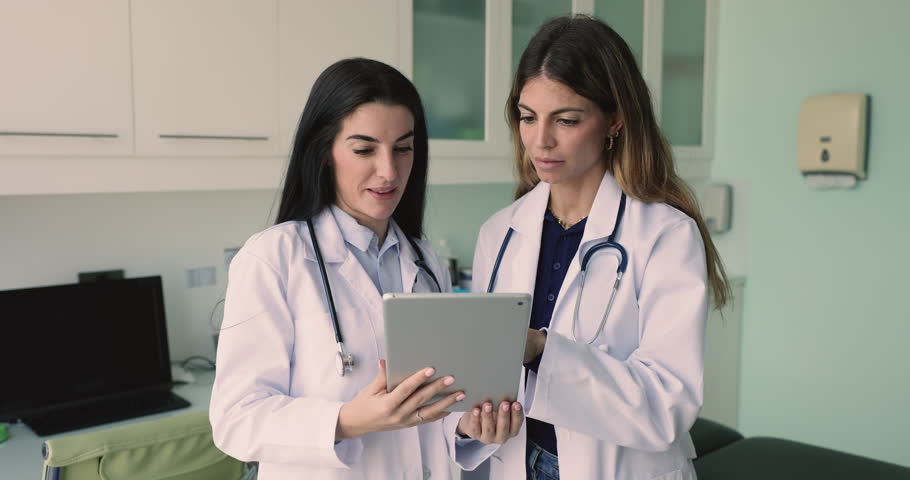 Two women GP colleagues using digital tablet, discussing patient cases, develop optimal treatment plans using application. Workflow and teamwork use modern tech, opinion, skills, knowledge exchange Royalty-Free Stock Footage #3470277437