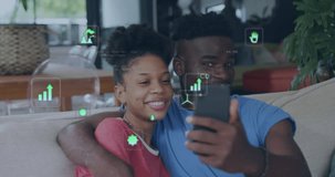 Animation of eco icons and data processing over happy african american couple using smarthopne. Global green energy, connections, computing and data processing concept digitally generated video.