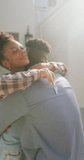 Vertical video of happy african american couple embracing at home. spending time together at home.