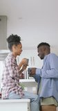 Vertical video of happy african american couple talking at home. spending time together at home.