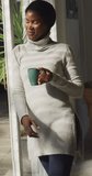 Vertical video of relaxed african american woman drinking coffee on patio. lifestyle and spending free time at home.