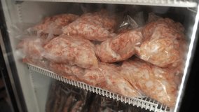 A close-up video shows plastic bags filled with frozen shrimp, including large ones, lying in the freezer. ones lying in the freezer.