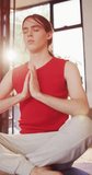 Vertical video of caucasian non-binary transgender woman practicing yoga, meditating. spending quality time at home alone, body inclusivity.