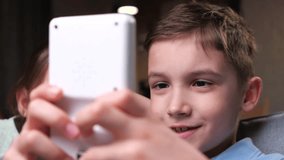 close-up portrait of boy playing an old vintage handheld console in white color