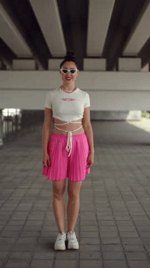 Vertical video. Slow motion. Street dance under bridge. A pretty girl in sunglasses and a pink skirt performs a street dance on a summer day outdoors under the city interchange bridge Adlı Stok Video