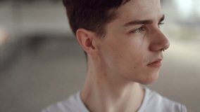 Slow motion. Close-up. Face of an upset guy looking at the camera while standing outdoors in the city during the day - Powered by Shutterstock - Get 15% off with code: PIKWIZARD15