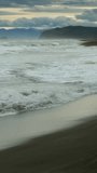 Khalaktyrsky beach with black sand and waves of Pacific ocean, Kamchatka peninsula, Russia. Vertical video