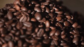 Beautiful time-lapse footage of falling coffee beans 4K. Slow motion of roasted coffee beans falling. Organic coffee seeds.