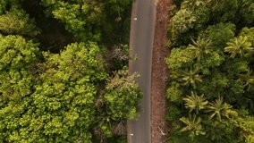 Aerial view of the road with cars passing by In the countryside with green forest and mountains. Footage 4 K road outside the city and the large forest. Top view for use as background, natural