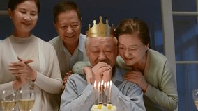 senior asian man with paper party hat celebrating birthday with old friends at home - Powered by Shutterstock - Get 15% off with code: PIKWIZARD15