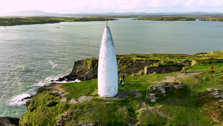 Tourists walking near the lighthouse Baltimore Beacon in County Cork, Ireland