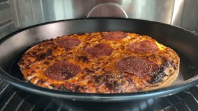 Interior video visual footage film video of an italian pizza in an hot heating oven in a kitchen  readu to be eated as it is roastedt toasted grill with yummy melting cheese and pepperoni tomato 