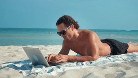Businessman working on laptop during summer vacation Against sounds surf male continues work in laptop combining relaxing. Laptop is source information that man to keep abreast of affairs away office. - Powered by Shutterstock - Get 15% off with code: PIKWIZARD15