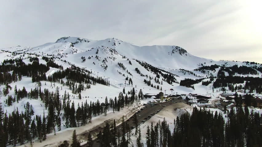 Aerial: Cars Parked On Road Amidst Snowy Mountains - Mammoth Lakes, California