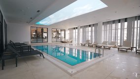 Indoor luxury pool in modern hotel spa with loungers, natural light, serene ambiance. Ideal for leisure, upscale travel,, relaxation. - Powered by Shutterstock - Get 15% off with code: PIKWIZARD15