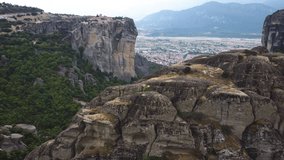Aerial view of Monastery of the Holy Trinity (Agia Triada) in Meteora, Greece with Kalabaka town and mountains in the background