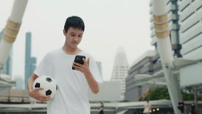 Asian Boy Walking Outside After Soccer Practice And Uses His Smartphone. Multiracial Guy After Football Match Going Home and Watching Funny Videos. Football and Technology Concept - Powered by Shutterstock - Get 15% off with code: PIKWIZARD15