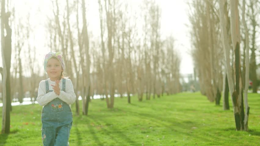 Little girl dancing in a beautiful park.