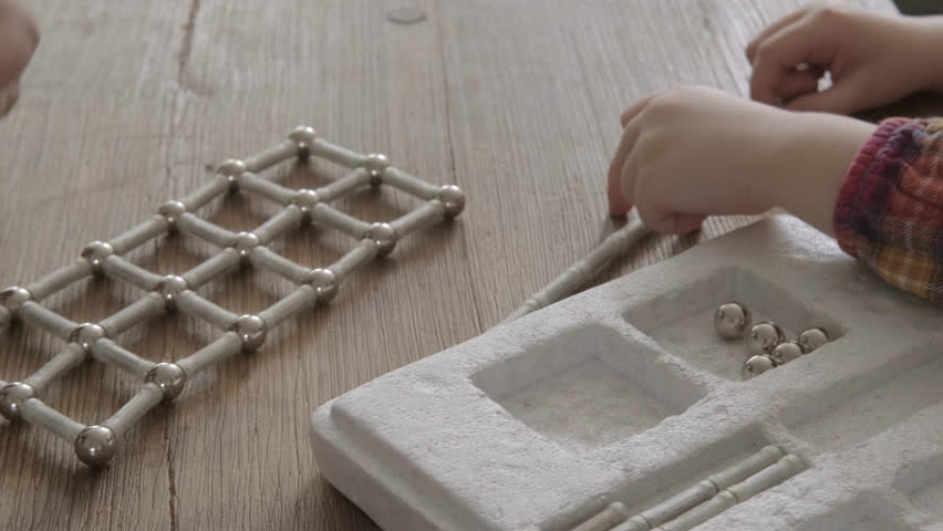 child, toddler assemble structures from magnetic constructor parts, development abstract, spatial thinking, child's imagination, engineering, fine motor skills