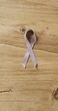 Vertical video of pink ribbon on wooden background. health, prevention, medicine, symbols and cancer awareness concept.