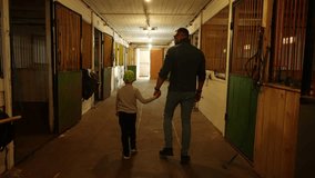 Father and son in stable corridor. Take walk around stables. Concept of peaceful unity - Powered by Shutterstock - Get 15% off with code: PIKWIZARD15