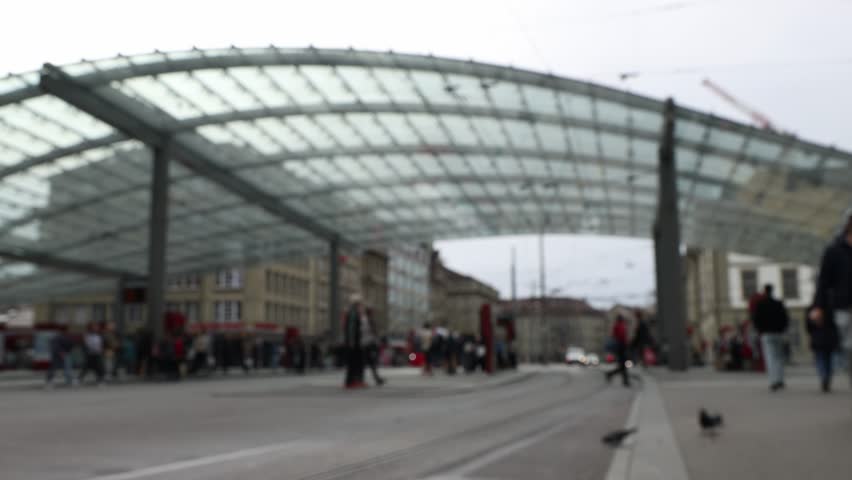 People and cyclists on main tram station in Bern, Switzerland, blurred background establisher