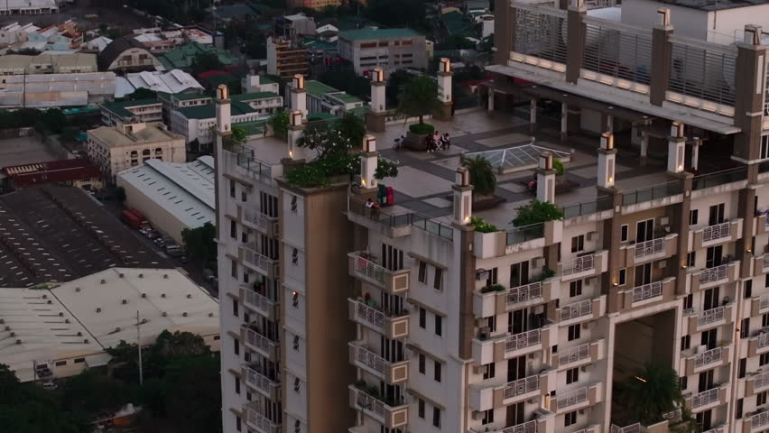 Aerial descending footage of terrace and balconies of Torre de Manila high rise residential building. Manila, Philippines