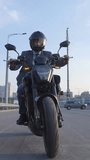 Caucasian man rides an electric motorcycle. Vertical video. 