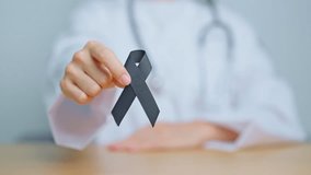 Melanoma and skin cancer, Vaccine injury awareness month and rest in peace concepts. woman holding black Ribbon - Powered by Shutterstock - Get 15% off with code: PIKWIZARD15
