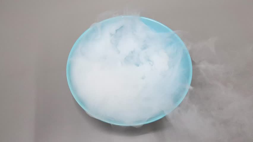 Dry ice reacting and sublimating in blue water Royalty-Free Stock Footage #3471295939