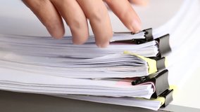 Businessman hands searching unfinished documents stacks of paper files on office desk for report papers, piles of papers sheet achieves with clips on desks, Document is written, drawn,presented.