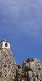 Portrait footage of The medieval castle known as Castell de Guadalest overshadowing the Guadalest valley in the Spanish town of Alicante in Spain on a sunny summers day with clouds in the sky