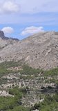 Portrait footage of a massive water reserve in the town of Guadalest, Alicante in Spain known as the Guadalest reservoir showing the blue water with mountains in the background