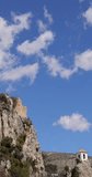 Portrait footage of The medieval castle known as Castell de Guadalest overshadowing the Guadalest valley in the Spanish town of Alicante in Spain on a sunny summers day with clouds in the sky