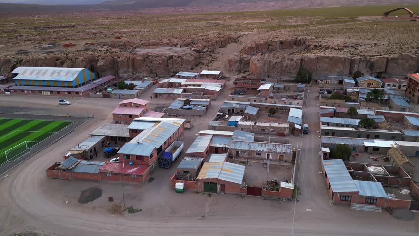 A colorful small town in chile with surrounding desert landscape, at dusk, aerial view