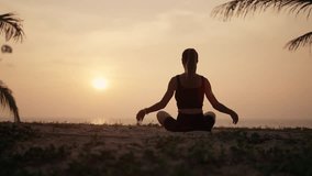 Woman practices yoga on ocean at sunset. Silhouette sporty yoga girl doing yoga pose asana exercise stretching at sunset on beach in nature close up. Peace, morning routine, relax on sea concept. - Powered by Shutterstock - Get 15% off with code: PIKWIZARD15