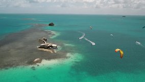 Stilt house and kite surfers on turquoise sea, aerial view - Powered by Shutterstock - Get 15% off with code: PIKWIZARD15