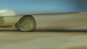 Extreme closeup: Knife chops cloves of garlic on wooden cutting board - Powered by Shutterstock - Get 15% off with code: PIKWIZARD15