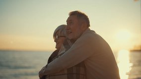 Happy laughing senior man hugging woman on sea beach at sunset in evening. Elderly couple family on date cuddling embracing talking. Lifelong relationships romantic marriage, enjoy leisure concept. - Powered by Shutterstock - Get 15% off with code: PIKWIZARD15
