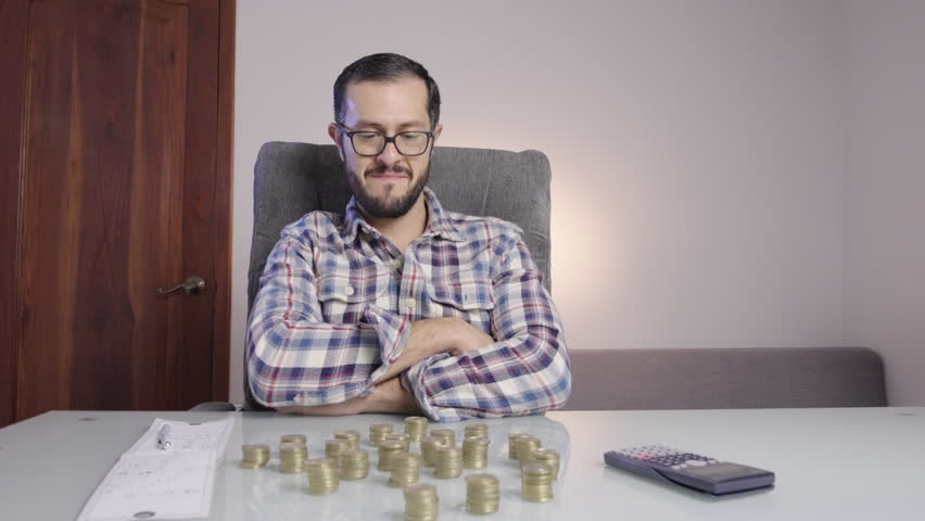 Young Man doing accounting and counting saving coins makes a happy satisfaction face. nest-egg piggy bank opening