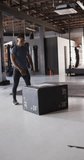 Vertical video of fit african american man jumping on block at gym. active, fit, sporty and healthy lifestyle, exercising at gym concept.