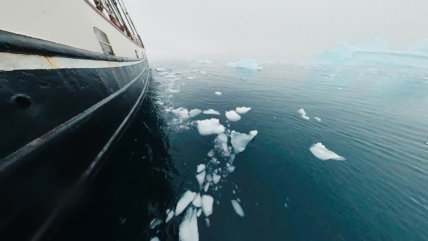 Antarctica sailing. Cruising sailing boat moves in Antarctica with ice floating in the water